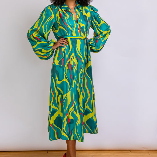 Model/Owner Robyn shows off the flow Cupro blend fabric of the Denver Abstract Printed Midi-length Shirt Dress in green and chartreuse.